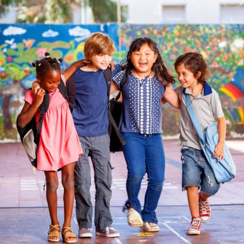 A group of children stand arm in arm.